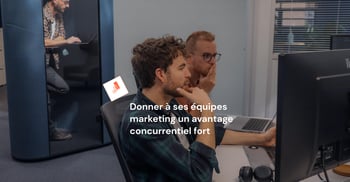 Photo de deux jeunes hommes de profil côté à côté pour regarder un écran d'ordinateur.