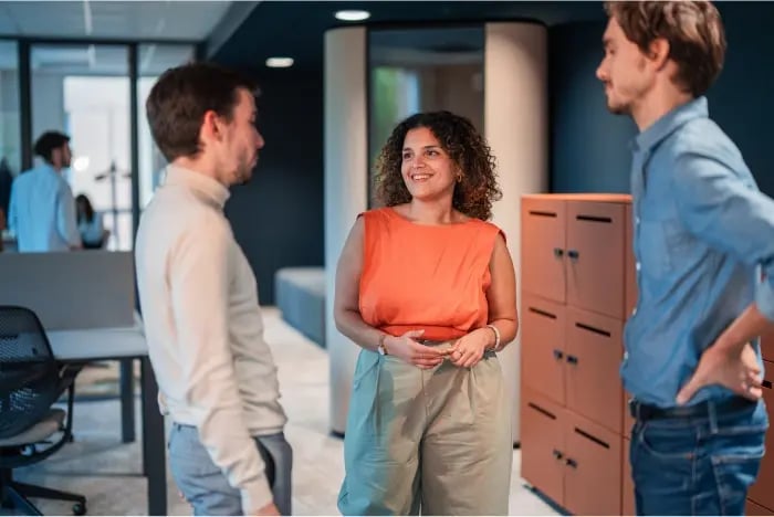 Trois salariés discutant dans l'open space de nos bureaux rennais