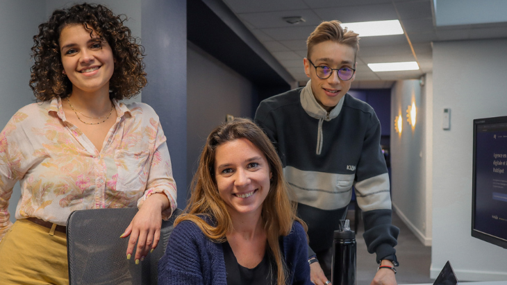 Trois personnes posant et souriant à la caméra